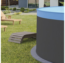 Záhradný pohľad s okrúhlym bazénom a drevenými ležadlami na trávniku