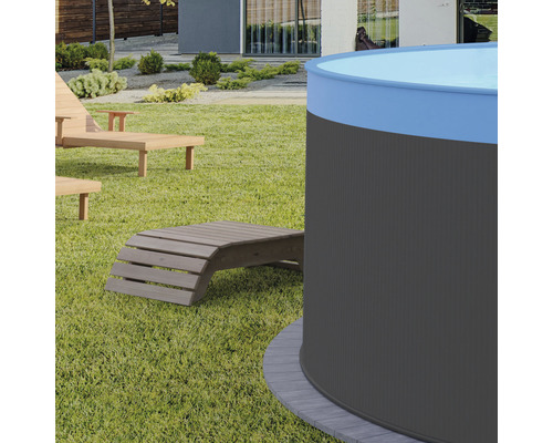 Záhradný pohľad s okrúhlym bazénom a drevenými ležadlami na trávniku