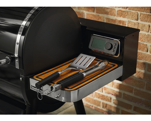 Detailný pohľad na gril Weber SmokeFire s grilovacím náčiním a digitálnym ovládaním.