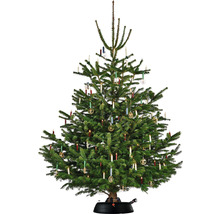 Ozdobený vianočný stromček so sviečkami a ozdobami na stojane