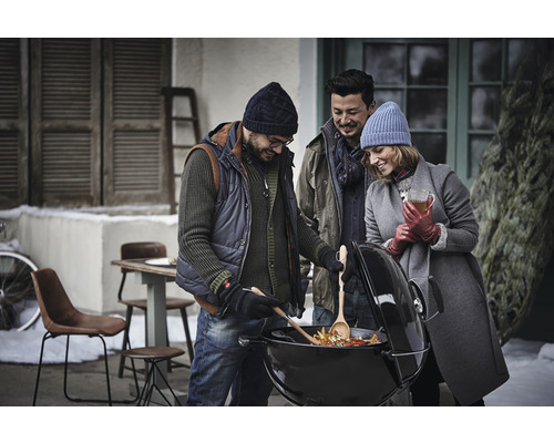 Skupina priateľov griluje zeleninu v zimnej záhrade na guľovom grile.