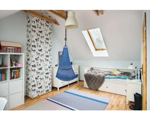 Svetlá detská izba s visiacim košom, posteľou a knižnicou pod strešným oknom.