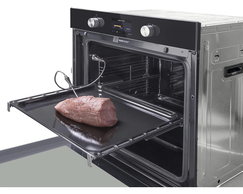 Otvorená rúra s teplomerom na pečenie a kusom mäsa na plechu