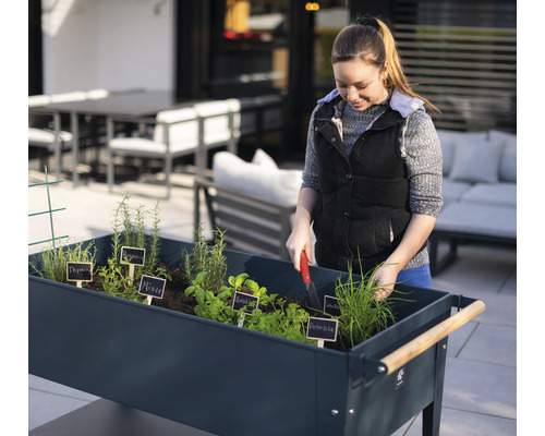 Žena pracuje na záhradnom záhone s bylinkami vonku