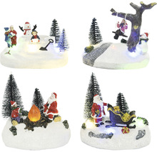 Rôzne vianočné dekorácie s figúrkami a stromami na zasneženom podklade.