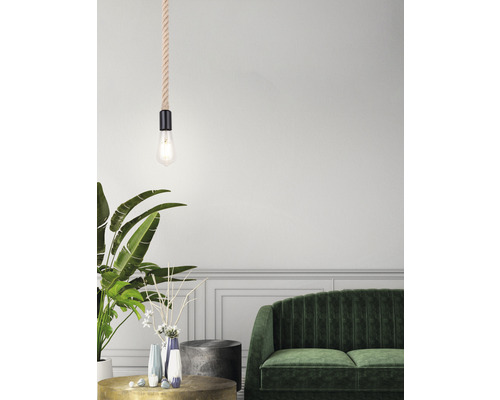 Dekoratívna obývacia izba s lanovým závesným svietidlom nad konferenčným stolíkom, zelenou pohovkou a izbovými rastlinami.