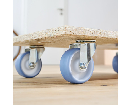 Nábytkové kolieska s modrými kolieskami pod drevenou doskou