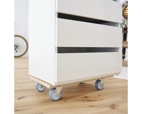 Nábytok na podvozku s kolieskami na drevenej podlahe.