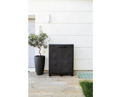 Záhradná skrinka s dvomi dvierkami vedľa olivovníka v kvetináči