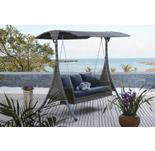 Záhradná hojdačka so strieškou, vankúšmi a dekoráciou na terase s výhľadom na more