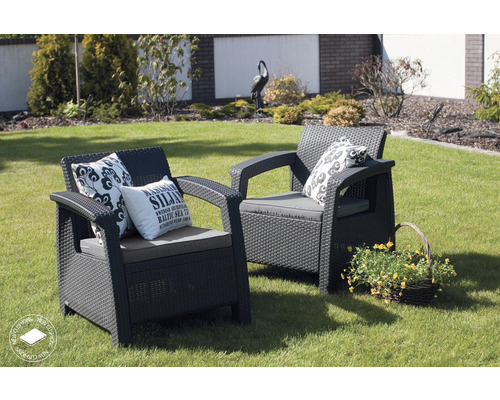 Dve ratanové kreslá s vankúšmi a dekoráciou v záhrade