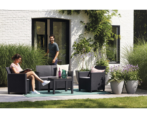 Záhradný nábytok na terase s dvoma ľuďmi a rastlinami v pozadí