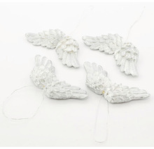 Štyri ozdoby anjelských krídel so závesnými šnúrami.