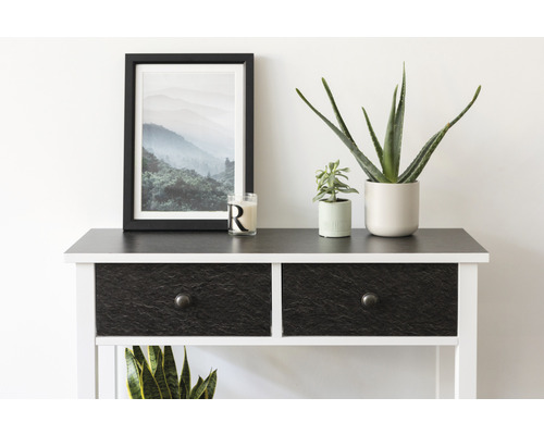 Dekoratívny príborník s dvoma zásuvkami, zarámovaný horský obraz, črepníkové rastliny a sviečka