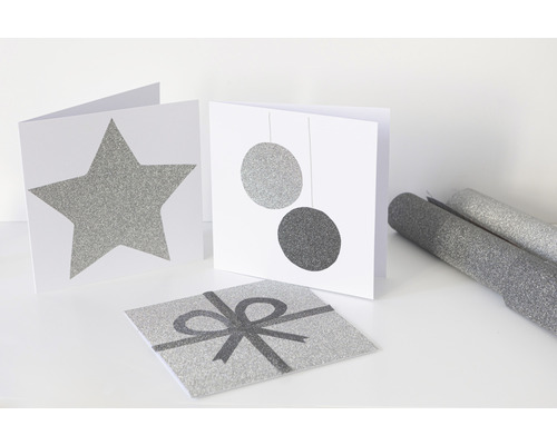 Dekoratívne karty s motívmi hviezdy, gúľ a darčekovej stuhy a rolky baliaceho papiera.