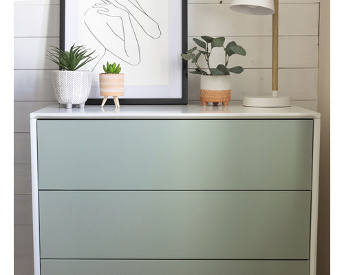 Komoda s tromi zásuvkami, rastlinami a lampou navrchu