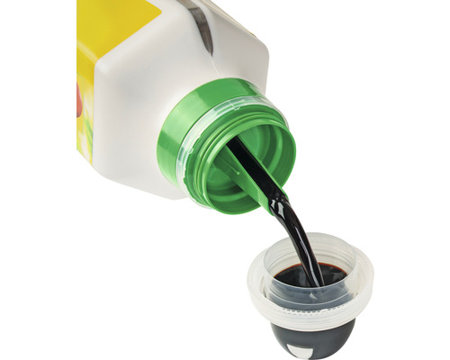 Tekuté záhradné hnojivo sa leje do odmerky