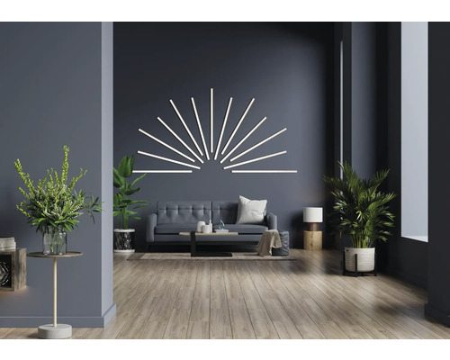 Obývacia izba s pohovkou, konferenčným stolíkom, izbovými rastlinami a nástenným svietidlom v tvare pruhov