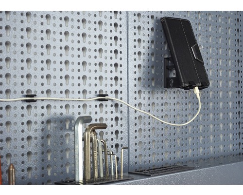 Dierovaná stena s náradím, tabletom a nabíjacím káblom.