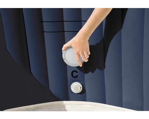 Detailný záber ruky pripevňujúcej uzáver na nafukovacej vírivke