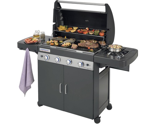 Plynový gril s grilovaným jedlom a otvoreným vekom