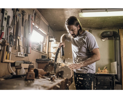 Muž upratuje ponk vysávačom v dielni