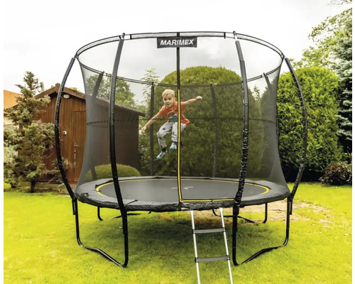 Okrúhla záhradná trampolína so sieťou a rebríkom, dieťa skáče na trampolíne