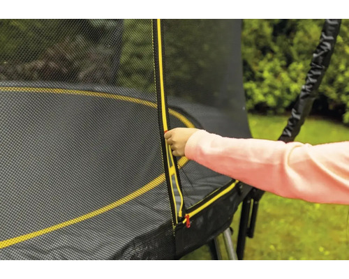 Dieťa otvára zips bezpečnostnej siete záhradnej trampolíny.