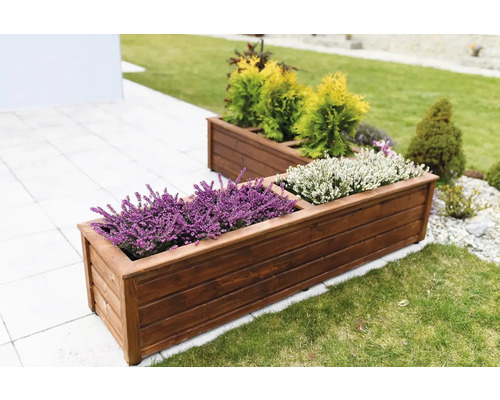 Dva obdĺžnikové drevené kvetináče s rastlinami v záhrade.