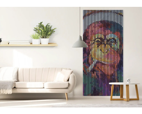 Obývacia izba s pohovkou, stolom a nástennou maľbou s vertikálnymi pruhmi a motívom opice