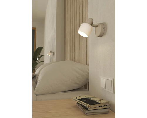 Spálňa s nástennou lampou, posteľou a nočným stolíkom
