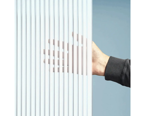 Detailný záber ryhovanej sklenenej dosky s rukou za ňou