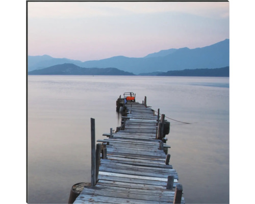 Drevené mólo pri jazere s horami v pozadí