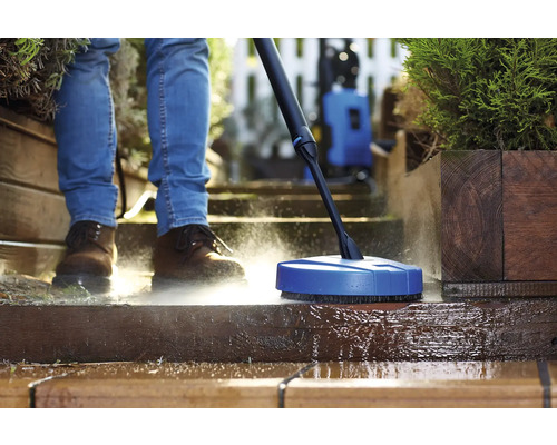 Osoba čistí terasu pomocou čističa povrchov a vysokotlakového čističa