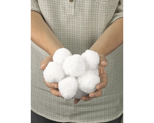 Osoba drží v rukách umelé snehové gule.