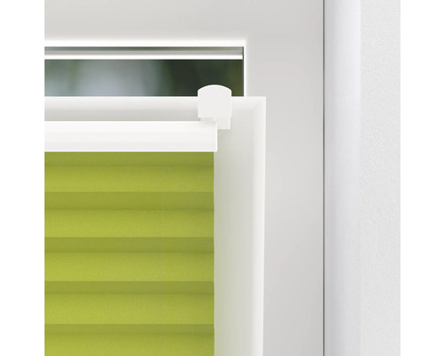Detailný záber zelenej plisovanej žalúzie na okne