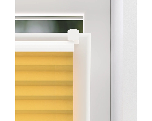 Detailný záber žltej plisovanej žalúzie na okne