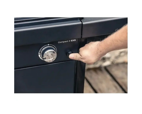 Osoba stlačí zapaľovacie tlačidlo plynového grilu