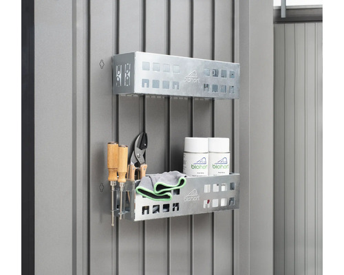 Dve kovové police s náradím, čistiacimi handričkami a sprejmi na stene