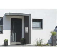 Vchodové dvere so strieškou a poštovou schránkou na stene domu