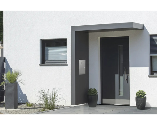 Vchodová strieška Gutta BS Plus 200 RAL 7016 antracit 200x90 cm, ľavý bočný diel vrátane poštovej schránky, funkčného boxu, nerezový odtok vody v bočnom diele Moderná fasáda domu s vchodovými dverami, oknom a kvetináčmi