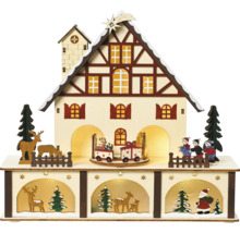 Dekoratívne vianočné osvetlenie domu s figúrkami a vláčikmi