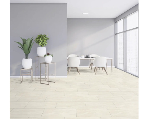 Svetlá, priestranná izba s jedálenským stolom, stoličkami, rastlinami a dlažbou