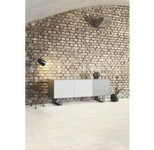 Obývacia izba s tehlovou stenou, komodou, stojacou lampou a dlažbou