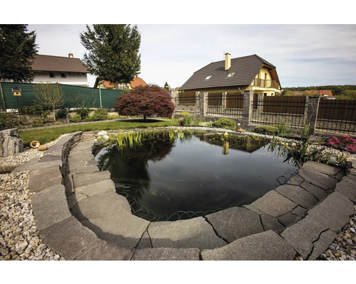 Záhradné jazierko s kamenným lemom a výsadbou vo vonkajšom prostredí