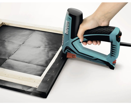 Osoba používa elektrickú zošívačku na napínanie plátna na drevený rám. Logo Novus.