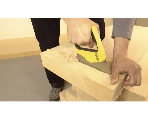 Muž pília drevo ručnou pílou.