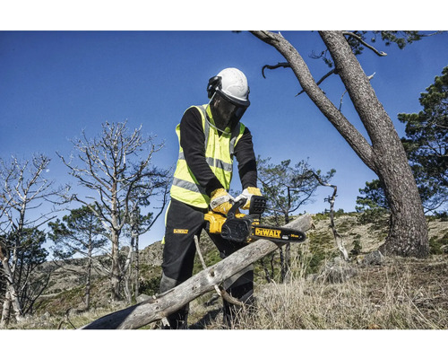 Osoba s ochrannými pomôckami reže kmeň stromu motorovou pílou DeWalt.