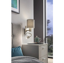 Nástenná lampa s lampičkou na čítanie nad nočným stolíkom v spálni.