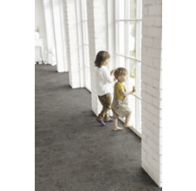 Deti stoja pri okne vo svetlej miestnosti s tmavou podlahovou krytinou